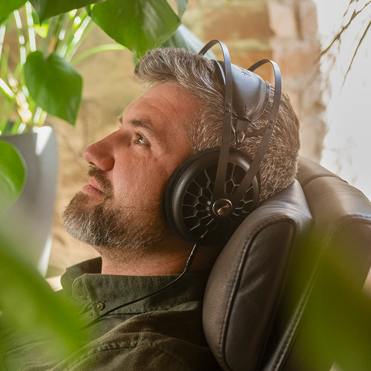 Man listening to Meze Audio premium build quality open-back dynamic drivers indoors