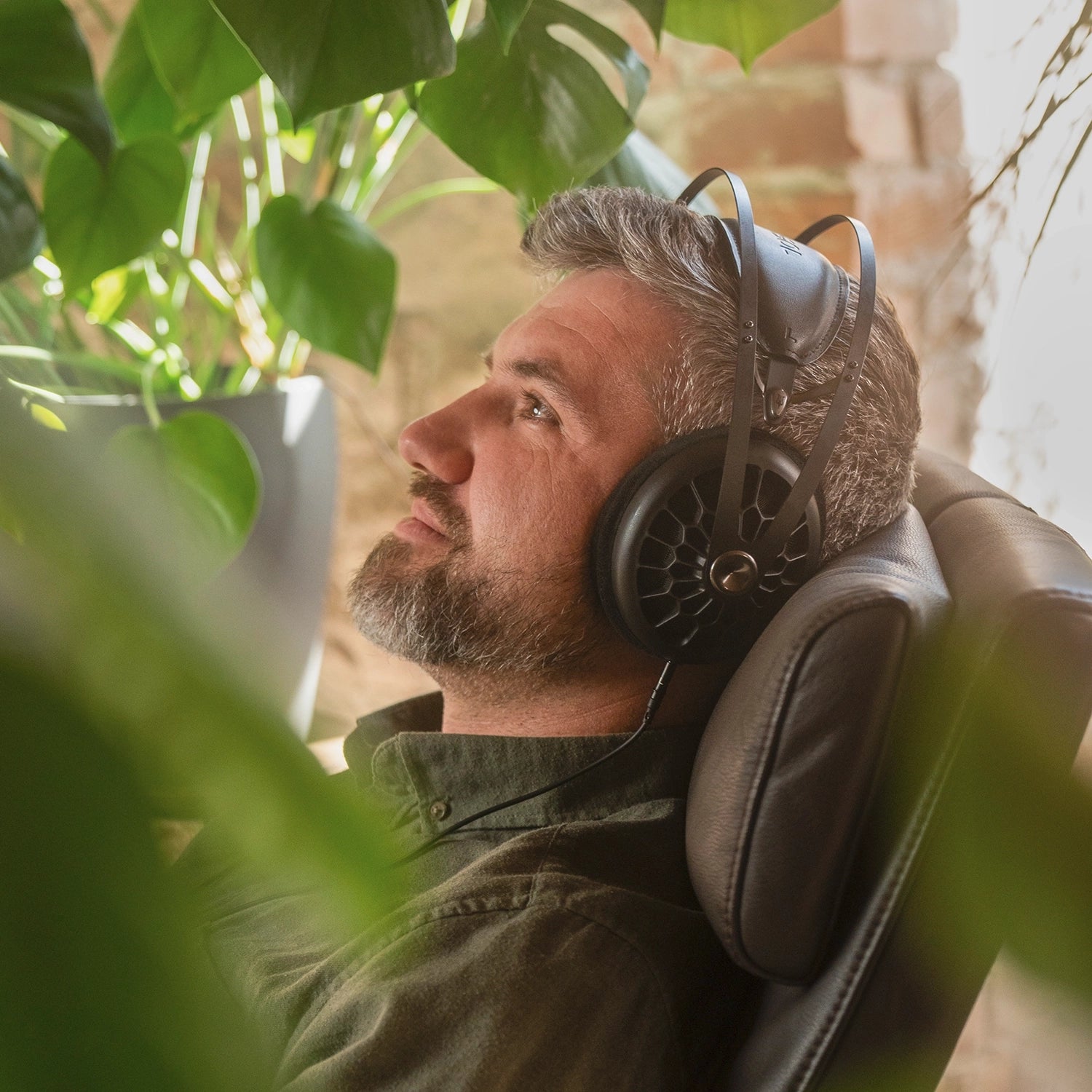 Meze Audio 109 PRO best open back premium audiophile high-fidelity headphones worn by man inside while sitting on an armchair