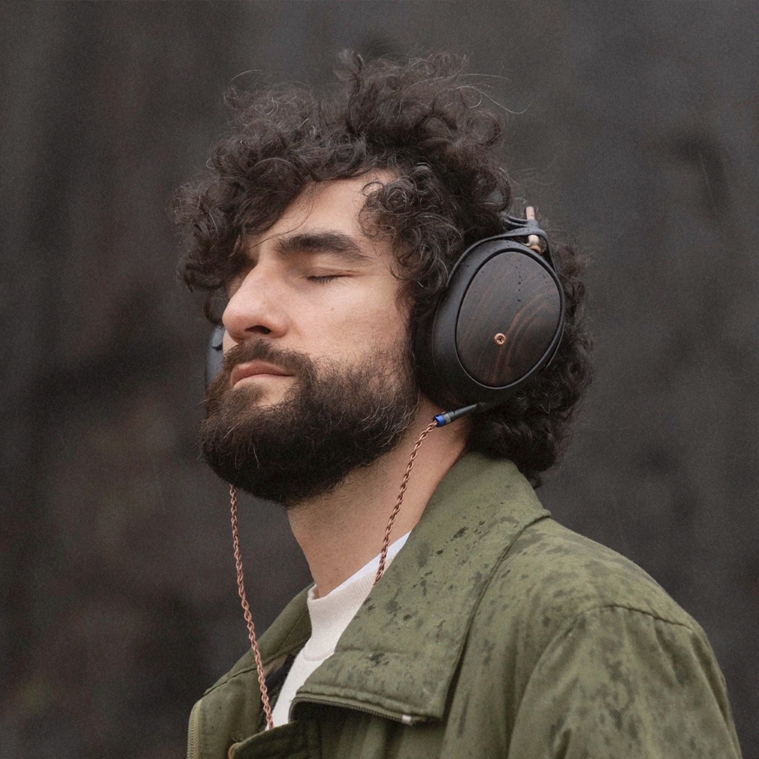 Man listening to Meze Audio Liric second generation premium build closed-back wooden ear cups copper cables outdoor