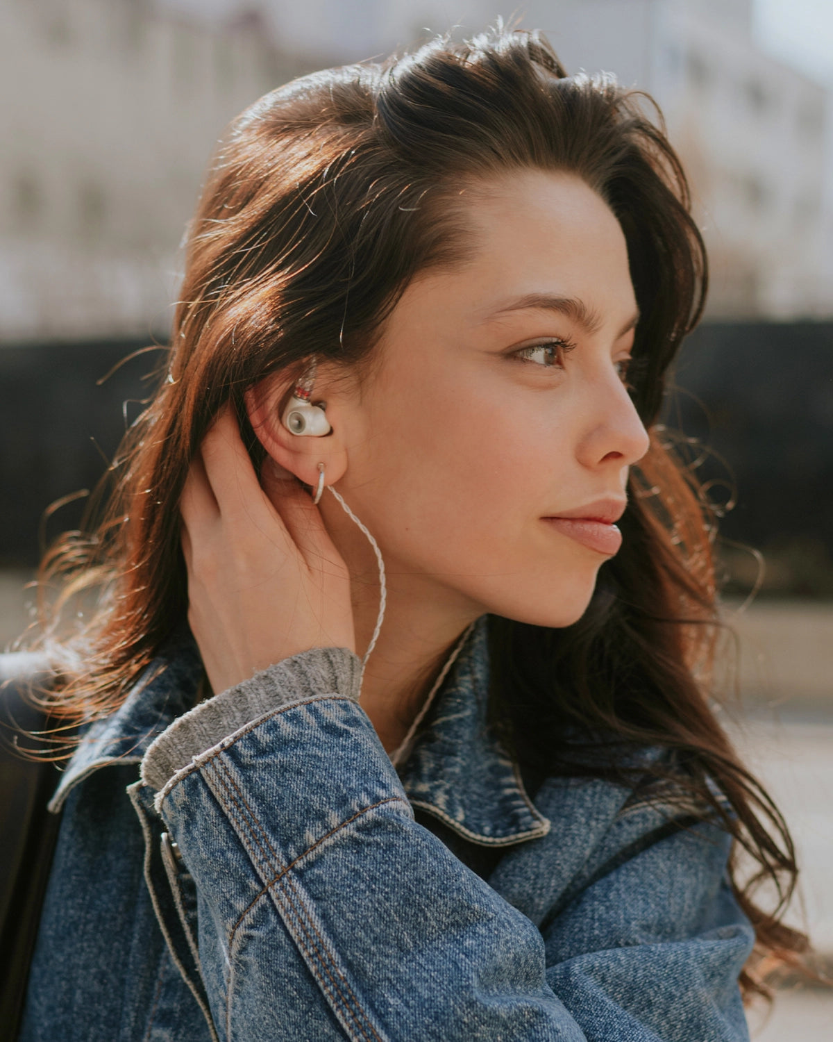 Young woman listening to Meze Audio premium IEM ALBA outdoor