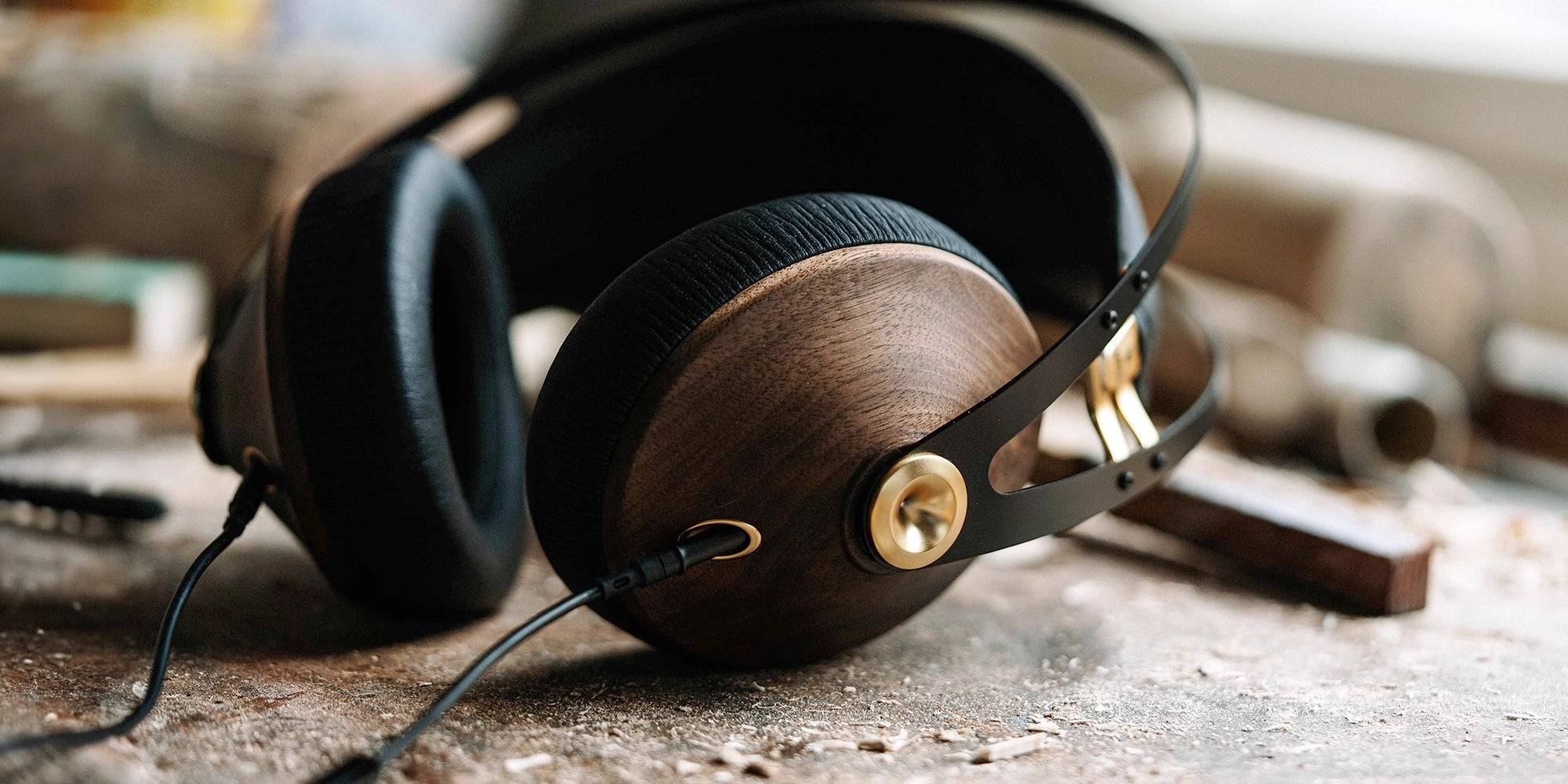 Detailed view of the walnut wood ear cups of the Meze Audio 99 Classics premium audiophile closed back headphones, showcasing the unique grain and craftsmanship.