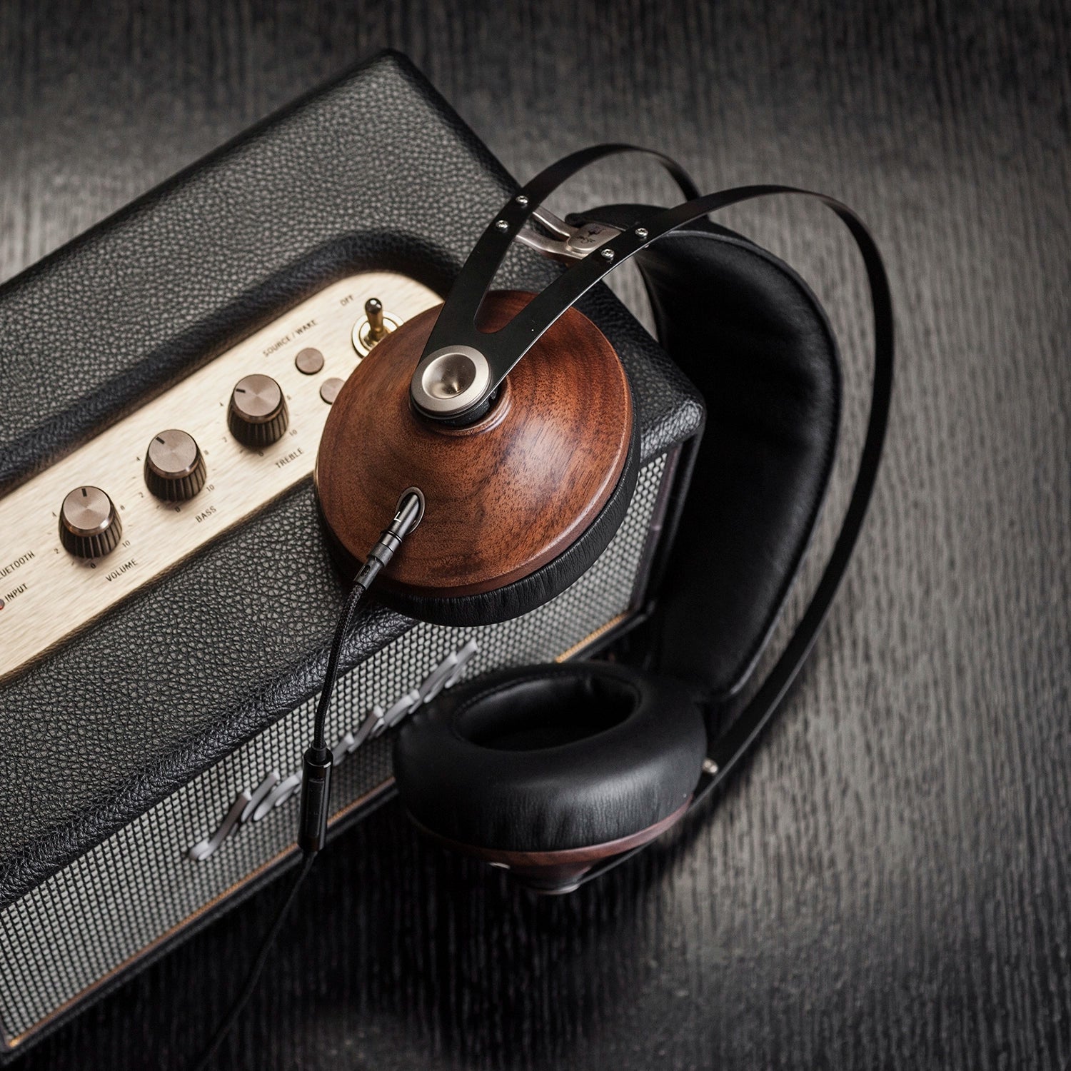 A pair of premium Meze Audio 99 Classics audiophile closed back headphones on an electric guitar amplifier