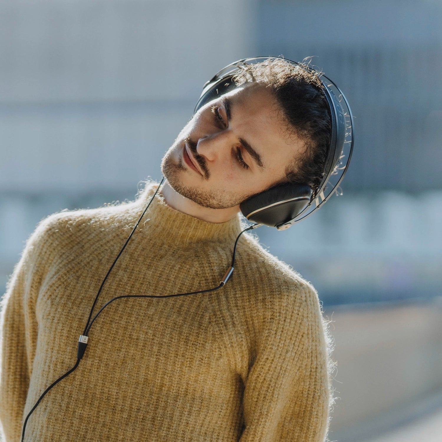 Man leaning to the left with his Meze Audio best wired closed-back audiophile headphones