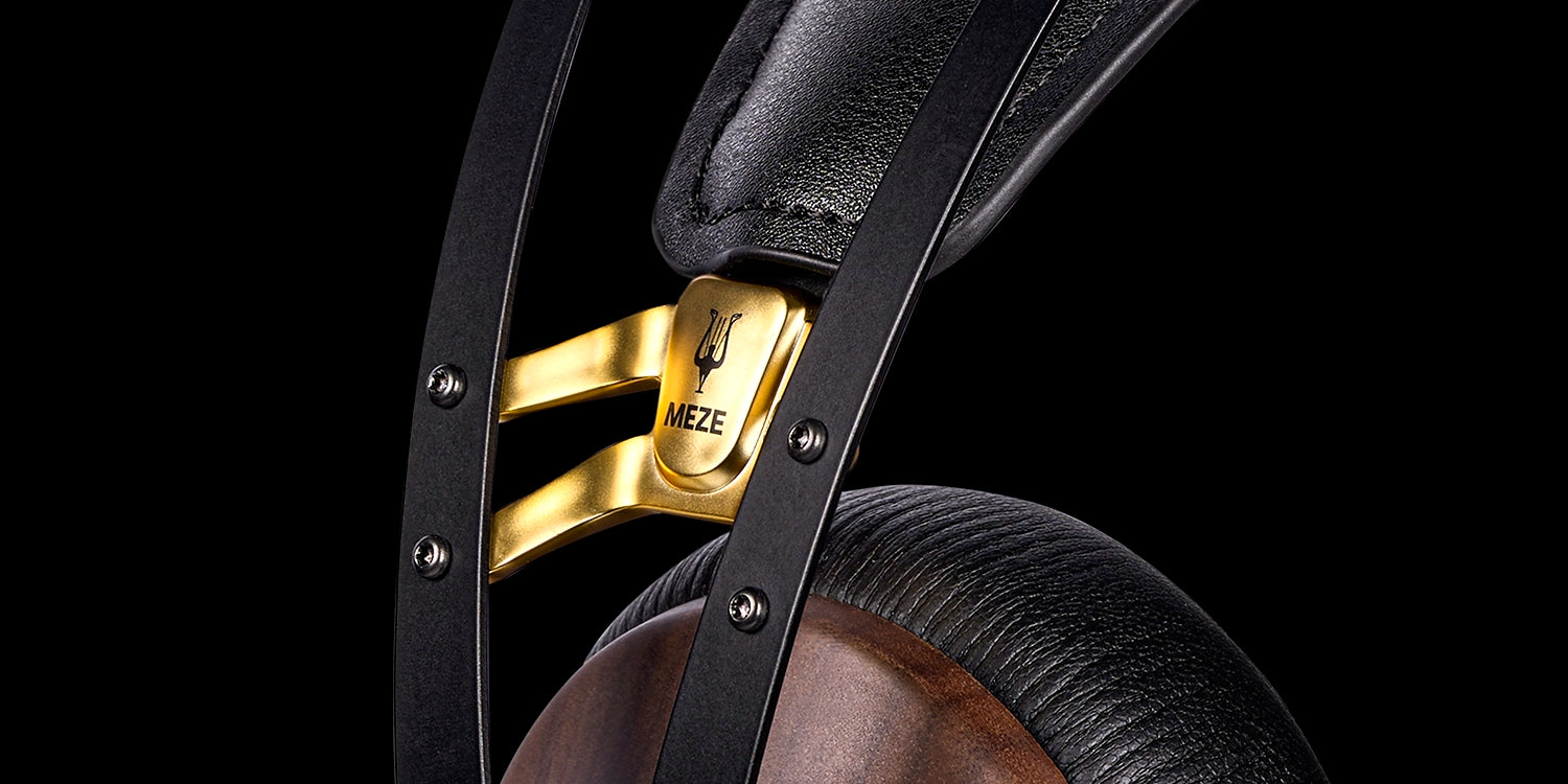 A pair of closed-back audiophile headphones with walnut wood ear cups and silver accents, designed for high-fidelity sound and comfort.