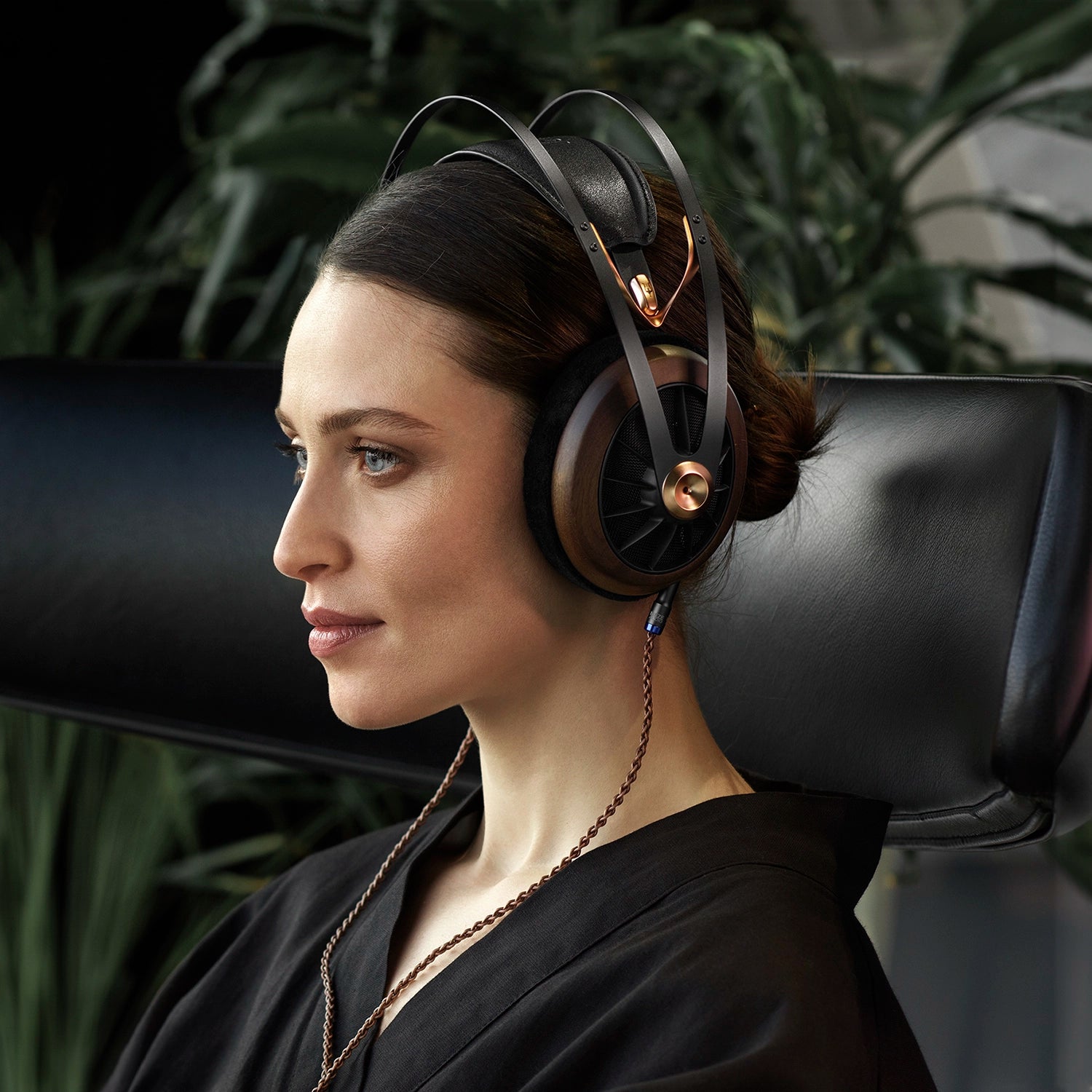 Woman listening to the Meze Audio 109 RPO Premium Audiophile Open-back headphone with the premium copper 4.4mm balanced copper cable