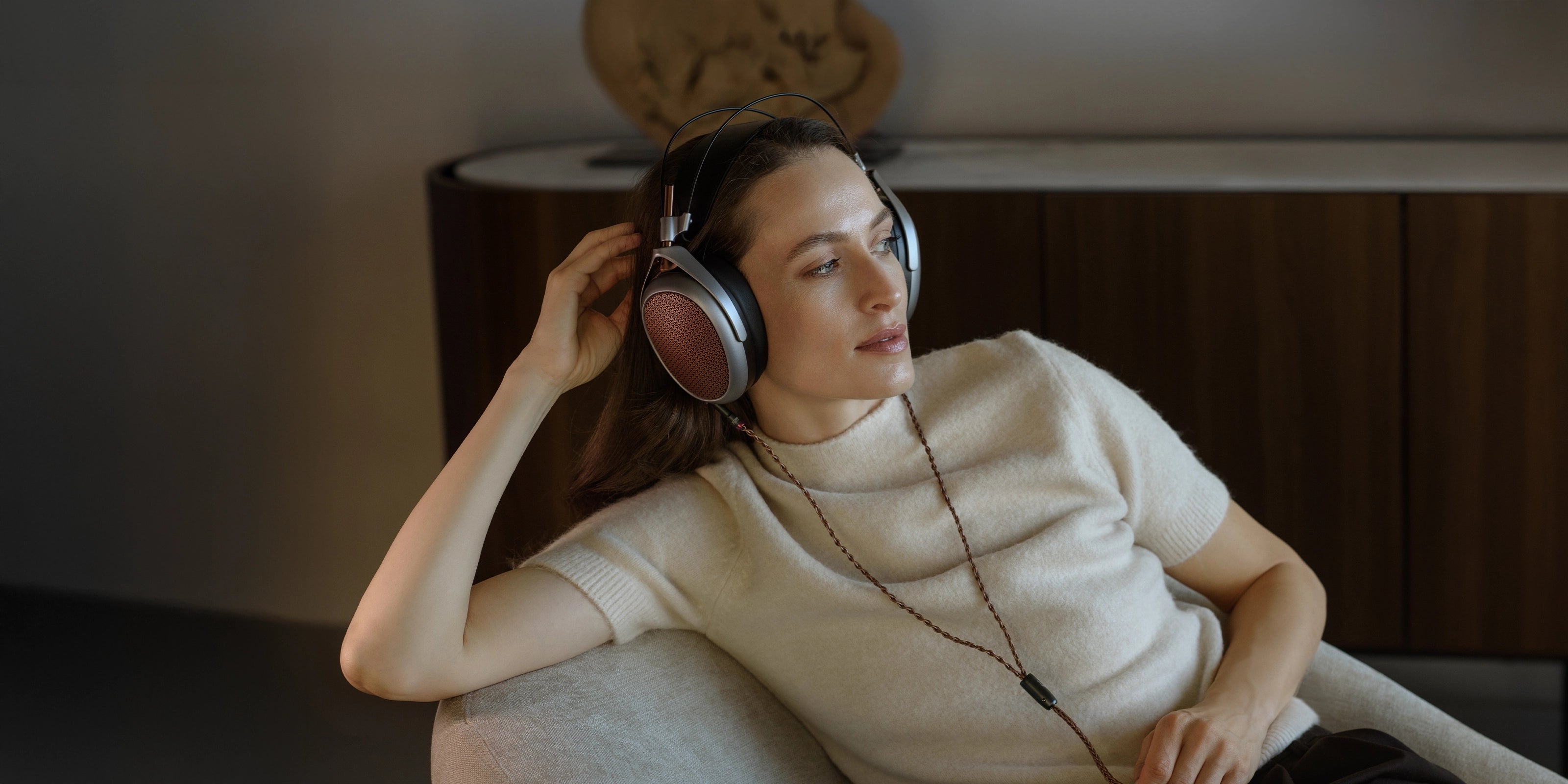 Woman listening Meze Audio POET planar magnetic open-back headphones copper ear cups premium build indoors