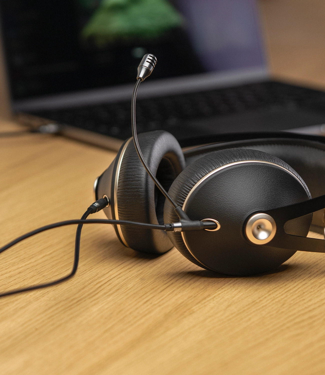 Meze Audio 99 Neo closed back Gaming Headset with Boom Mic on a desk in front of a laptop